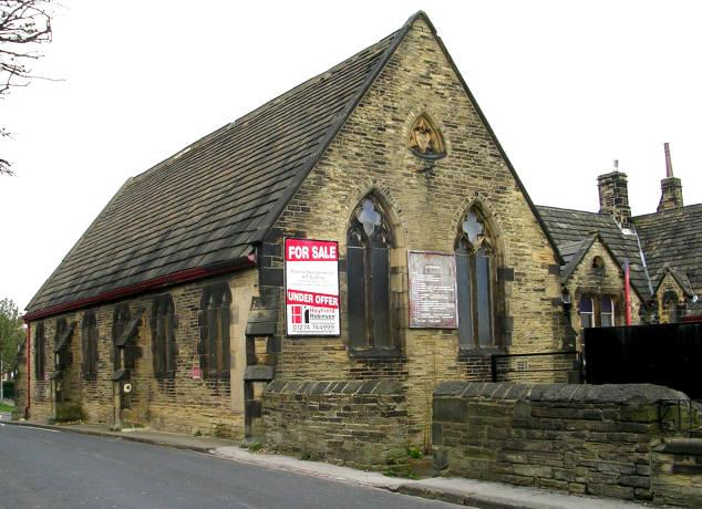 A church building featuring for sale sign