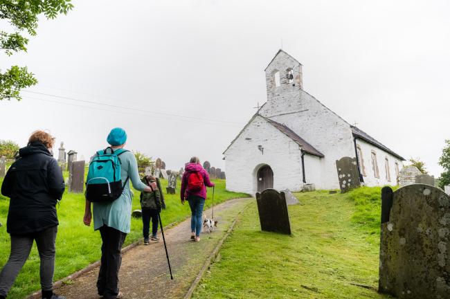 A photograph of people walking up to a Welsh chapel