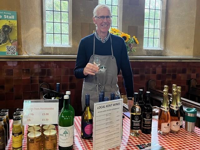 A man stands at a stall selling wine