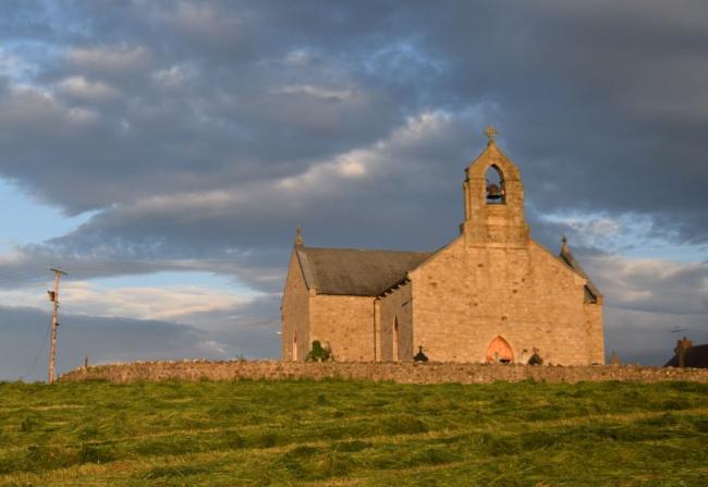 St Macartans (the forth chapel) in Augher, County Tyrone with blue and cloudy skies in the background.