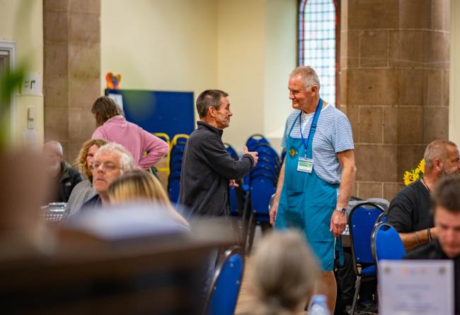 Two men having a conversation inside a church