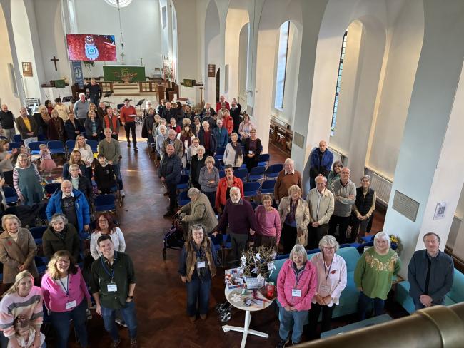 A congregation of people inside a church, facing the camera above them