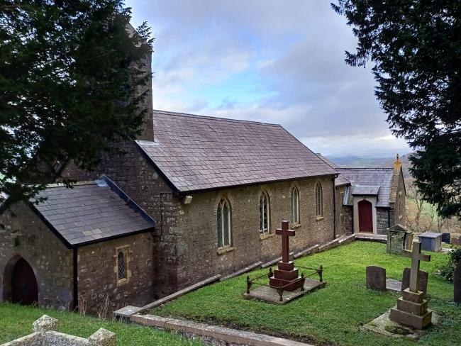 A church on the left and its churchyard on the right.