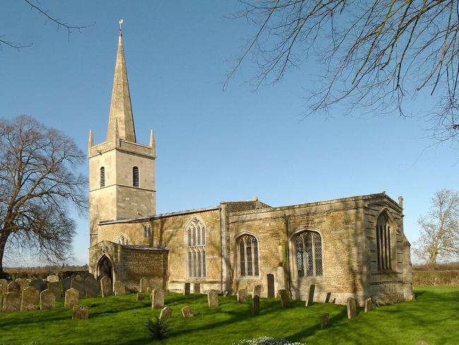 A yellow-coloured church pictured against a clear sky