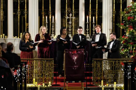 A group of singers, performing carols in a church