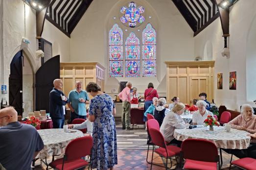 People sitting at tables inside a church