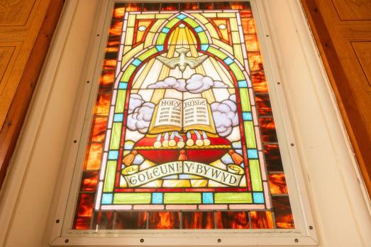 A bilingual stained glass window in Bethesda Presbyterian Chapel in Mold, Flintshire. It is brightly coloured.